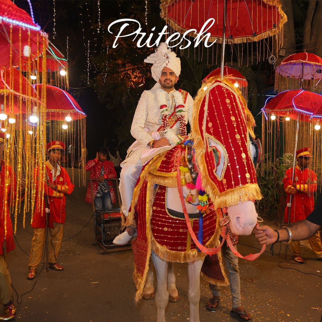Groom making a royal Baraat entrance on a decorated white horse