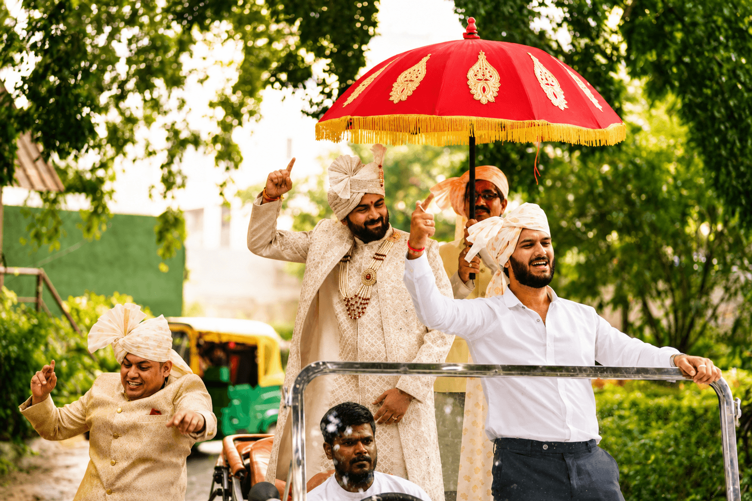 Groom moving through his Baraat beneath a royal Chhatri